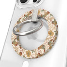 Close-up of the Boot Scootin' Christmas MagSafe grip ring with cowboy boots and hats on cream and a brushed silver ring on a clear iPhone case