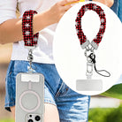 Buffalo Plaid Snowflake scrunchie phone strap worn on the wrist with an iPhone hanging from it, plus close-up of the strap and phone tab