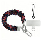 The USA Fireworks scrunchie phone wrist strap shown on its own in red, white and blue fireworks, with the silver lobster clasp, black loop cord and phone attachment tab.