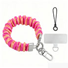 Pink and orange striped Candy Citrus Stripes scrunchie phone wrist strap clipped to the matching hot pink and citrus orange striped Wavy Luxe iPhone case, styled on a playful pink and orange heart print background.