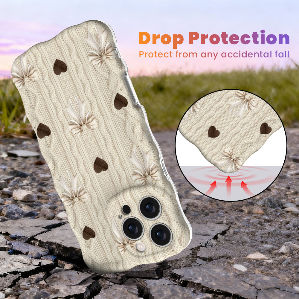 Front view of Sweater Weather Sweetheart Wavy Luxe MagSafe iPhone case highlighting the cream knit texture with taupe bows and brown hearts.