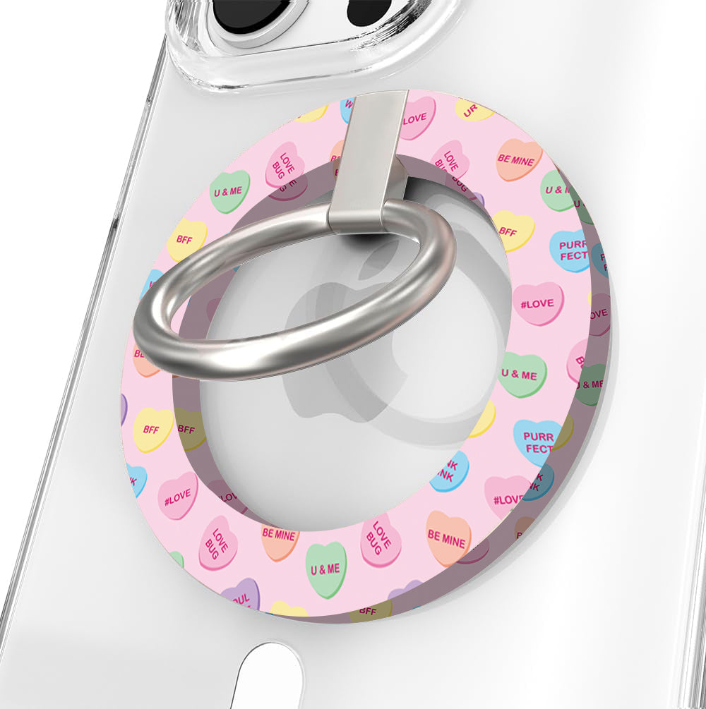 Conversation Hearts pattern MagSafe phone grip ring with pastel candy hearts and "Be Mine" text on pink background compatible with iPhone and Samsung