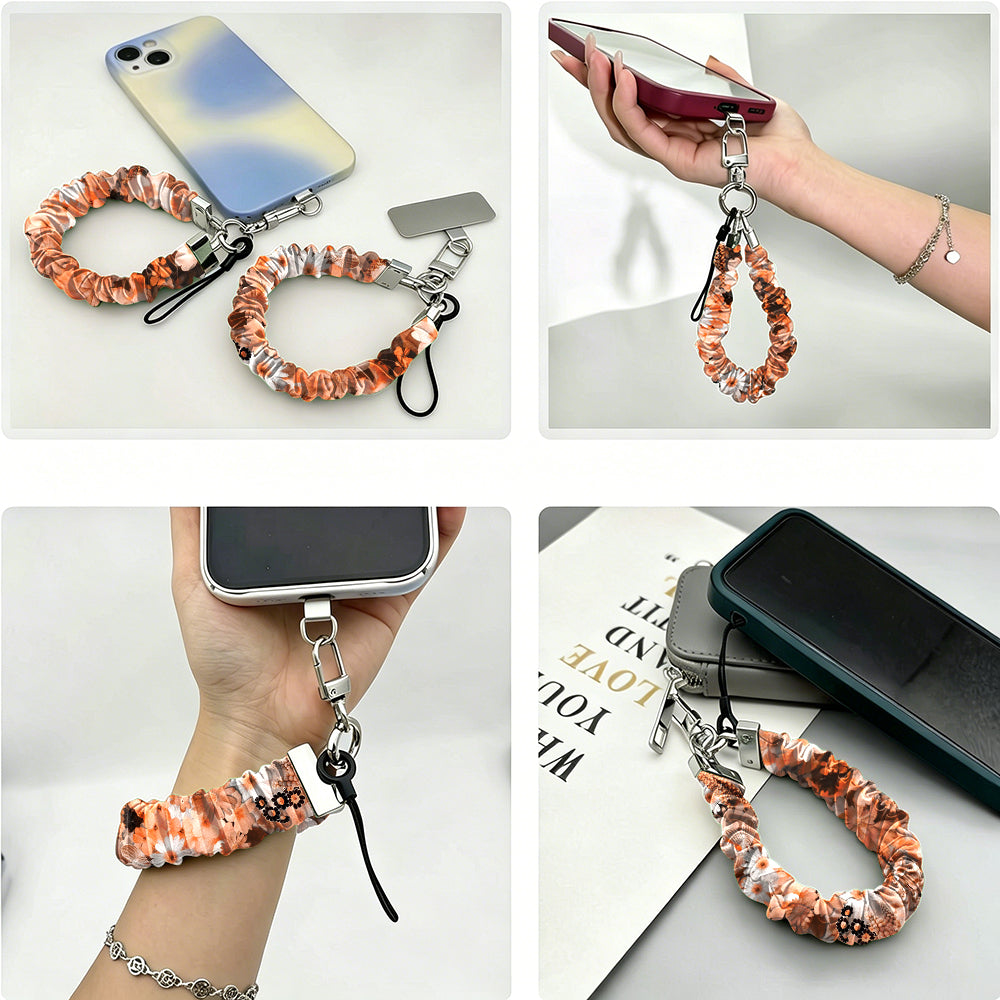 Fall Blooms scrunchie phone wrist strap shown from four angles - clipped to an iPhone, held in hand, worn on the wrist and laid flat - in an orange and cream autumn floral print