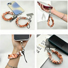 Fall Blooms scrunchie phone wrist strap shown from four angles - clipped to an iPhone, held in hand, worn on the wrist and laid flat - in an orange and cream autumn floral print