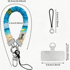 Blue and green satin Beach Please scrunchie phone wrist strap clipped to the matching Beach Please Wavy Luxe iPhone case with a beach chair and cocktail design, styled on a sandy shoreline background with starfish and ocean waves.