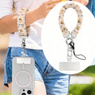 A sweet Bee Happy scrunchie phone wrist strap in a white bumblebee, honeycomb, and honey-pot print, clipped to the matching Bee Happy Wavy Luxe iPhone case, styled with sunflowers and bees on a soft cream background.