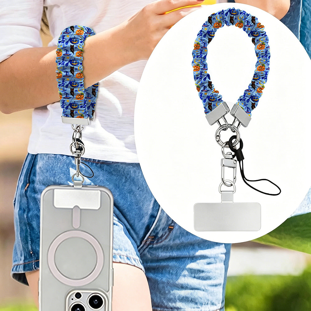 The Bewitching Hour scrunchie phone wrist strap in periwinkle blue witch print, worn on the wrist with the phone hanging