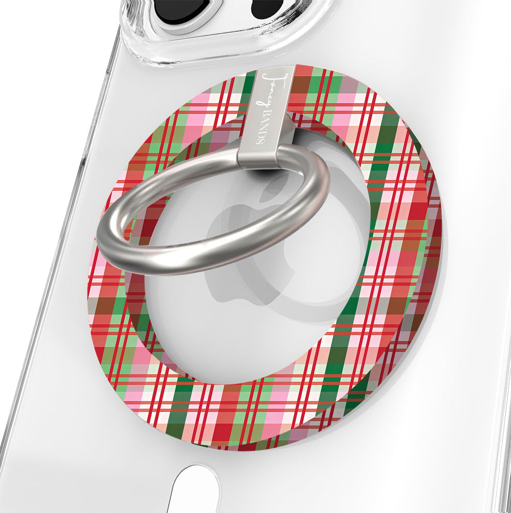 Close-up of the Merry Little Plaid MagSafe grip ring in pink, red and green Christmas plaid with a brushed silver ring on a clear iPhone case