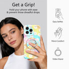 Daisy Dream MagSafe grip ring with pastel rainbow waves and white daisies on phone