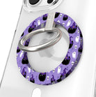 Ghostly Whisker's Hold It Fancy MagSafe grip ring close-up on a clear iPhone case, showing the lavender ring with white ghosts, black cats and witch hats around the silver rotating ring.