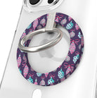 Close-up of the Just One More Ornament MagSafe grip ring with pink and aqua ornaments on plum and a brushed silver ring on a clear iPhone case