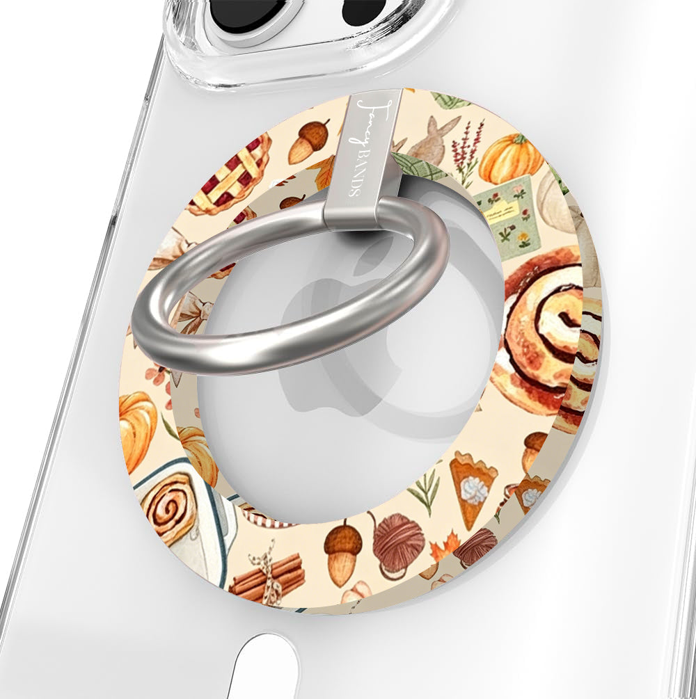 All The Fall Things Hold It Fancy MagSafe grip ring close-up on a clear iPhone case, showing the cream ring painted with watercolor pumpkins, cinnamon rolls, acorns and autumn leaves around the silver rotating ring.