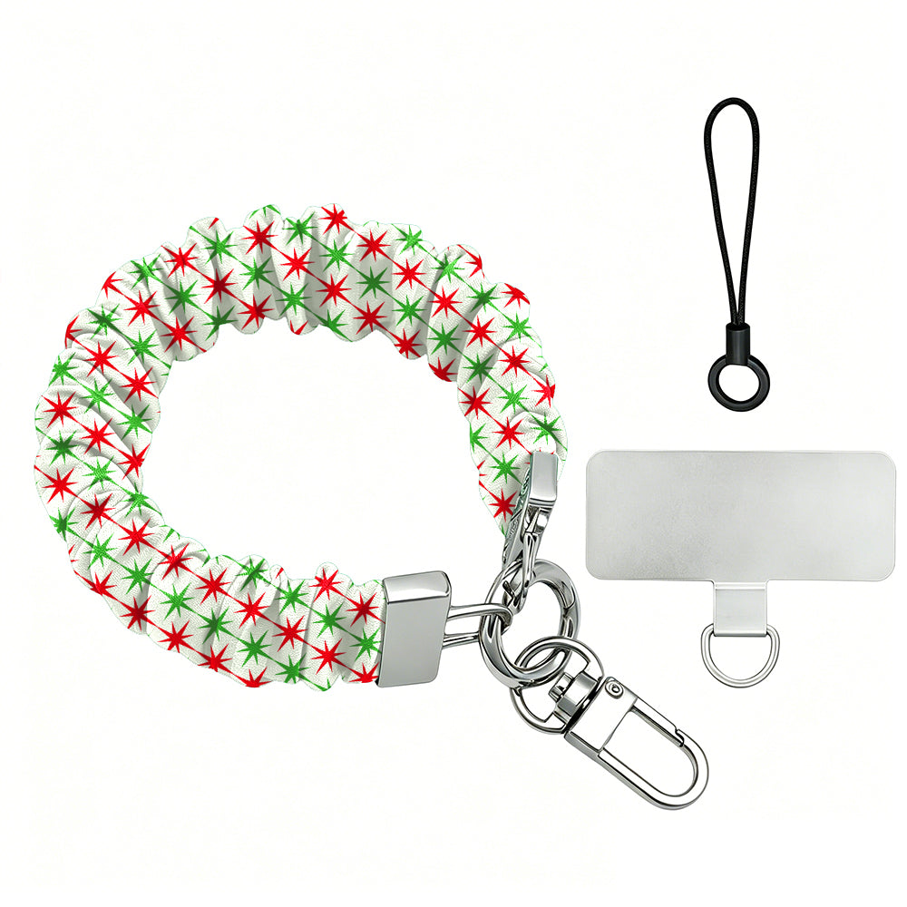 Tinsel & Stardust scrunchie phone wrist strap laid flat, red and green starbursts on cream, with silver clasp, lanyard loop and phone tab
