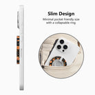 Slim design diagram for the Haunted Blossoms MagSafe grip ring, showing the low-profile collapsible ring sliding easily into a pocket.