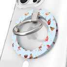 Close-up of the Holiday Spirits, Please? MagSafe grip ring with holiday cocktails and ribbon bows on powder blue and a brushed silver ring on a clear iPhone case