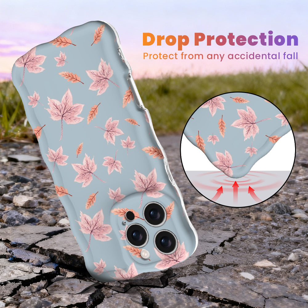 Drop protection diagram for the Autumn Breeze Wavy Luxe iPhone case, showing the shock-absorbing raised edges that protect the blue and blush maple leaf print against accidental falls.