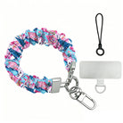 Sugarplum Square scrunchie phone wrist strap laid flat with silver clasp and phone tab, pink gingerbread houses and blue pines