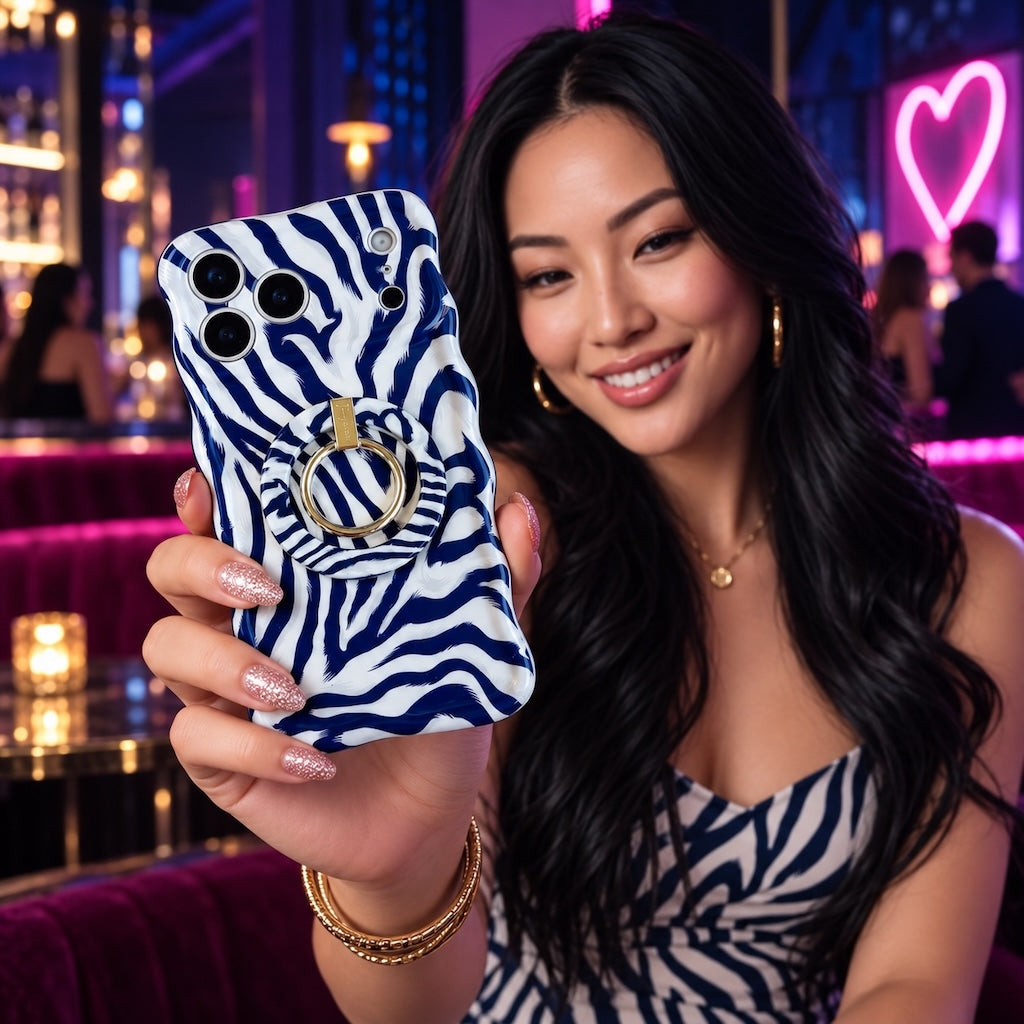 Woman holding the Zebra, Obviously navy zebra print iPhone case fitted with the matching MagSafe grip ring at a neon-lit cocktail bar.
