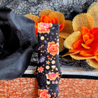 Close-up of the Haunted Blossoms Samsung Galaxy Watch band against black tulle, showing coral roses and tiny purple bats.