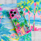 Trendy wavy iPhone case featuring a vibrant tropical resort scene with pink villas and green palm trees with a high-gloss finish.
