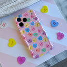 Pink wavy iPhone case featuring colorful candy conversation hearts with text like Be Mine, Ur Hot, and Soul Mate.