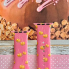 Caramel Coated Cutie Apple Watch band front view of both strap halves against a caramel apple backdrop, showing the pink silicone and the adjustment pin holes.