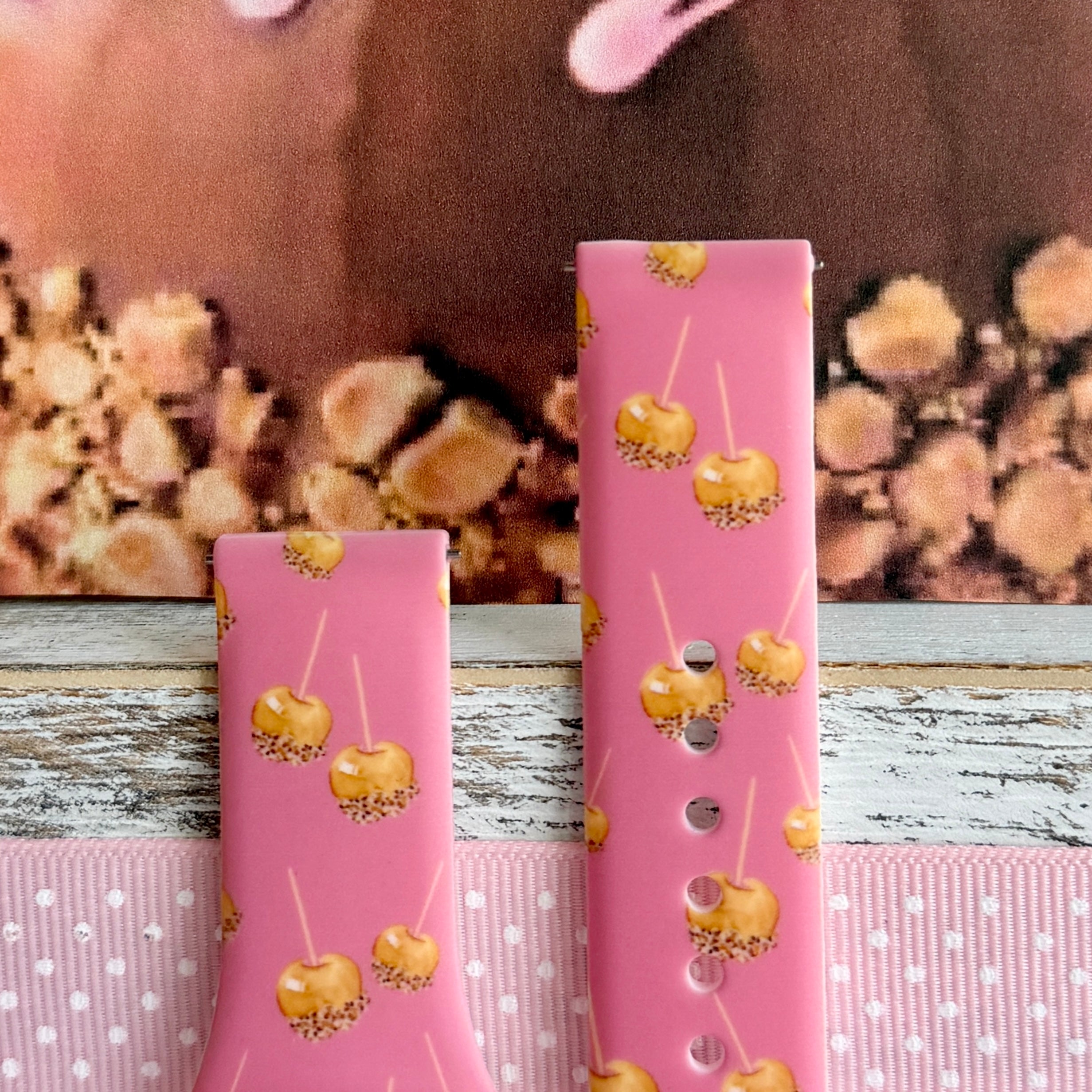 Caramel Coated Cutie Samsung Galaxy Watch band front view of both strap halves against a caramel apple backdrop, showing the pink silicone and quick-release pin holes.