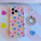 Conversation Hearts pattern MagSafe phone grip ring with pastel candy hearts and "Be Mine" text on pink background compatible with iPhone and Samsung