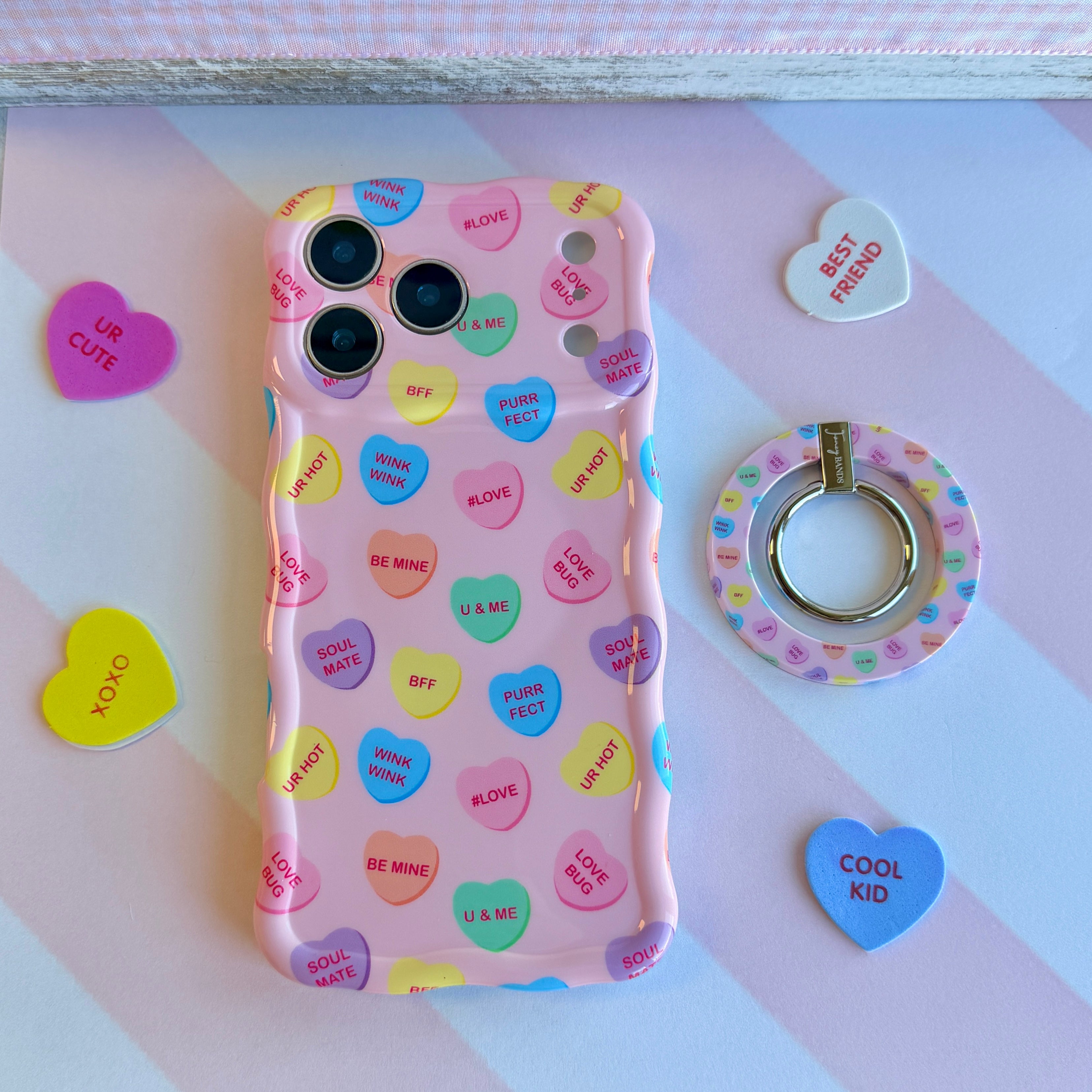 Conversation Hearts pattern MagSafe phone grip ring with pastel candy hearts and "Be Mine" text on pink background compatible with iPhone and Samsung