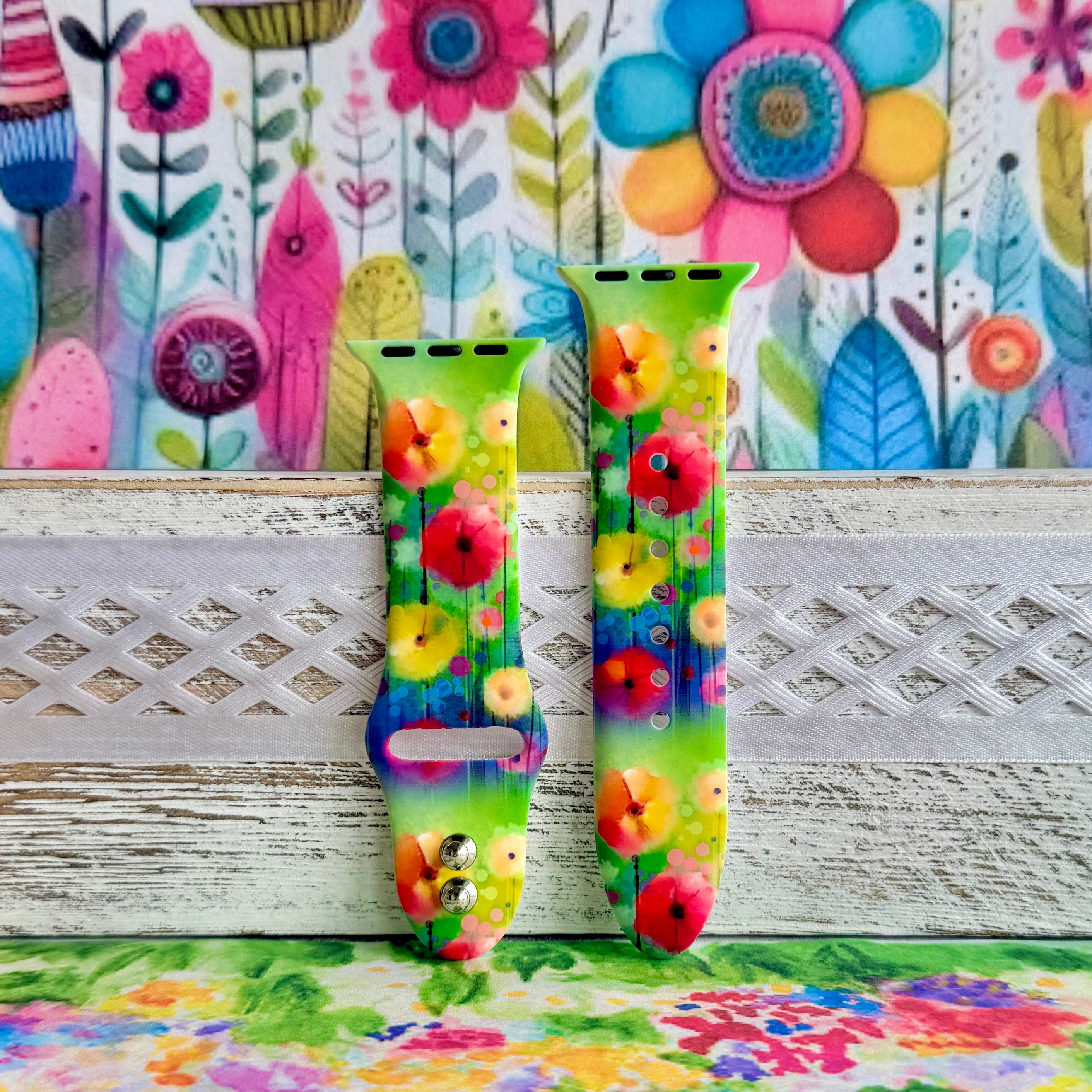 Petal Princess Apple Watch band with vibrant watercolor flowers in red, orange, yellow, pink, and blue on green background
