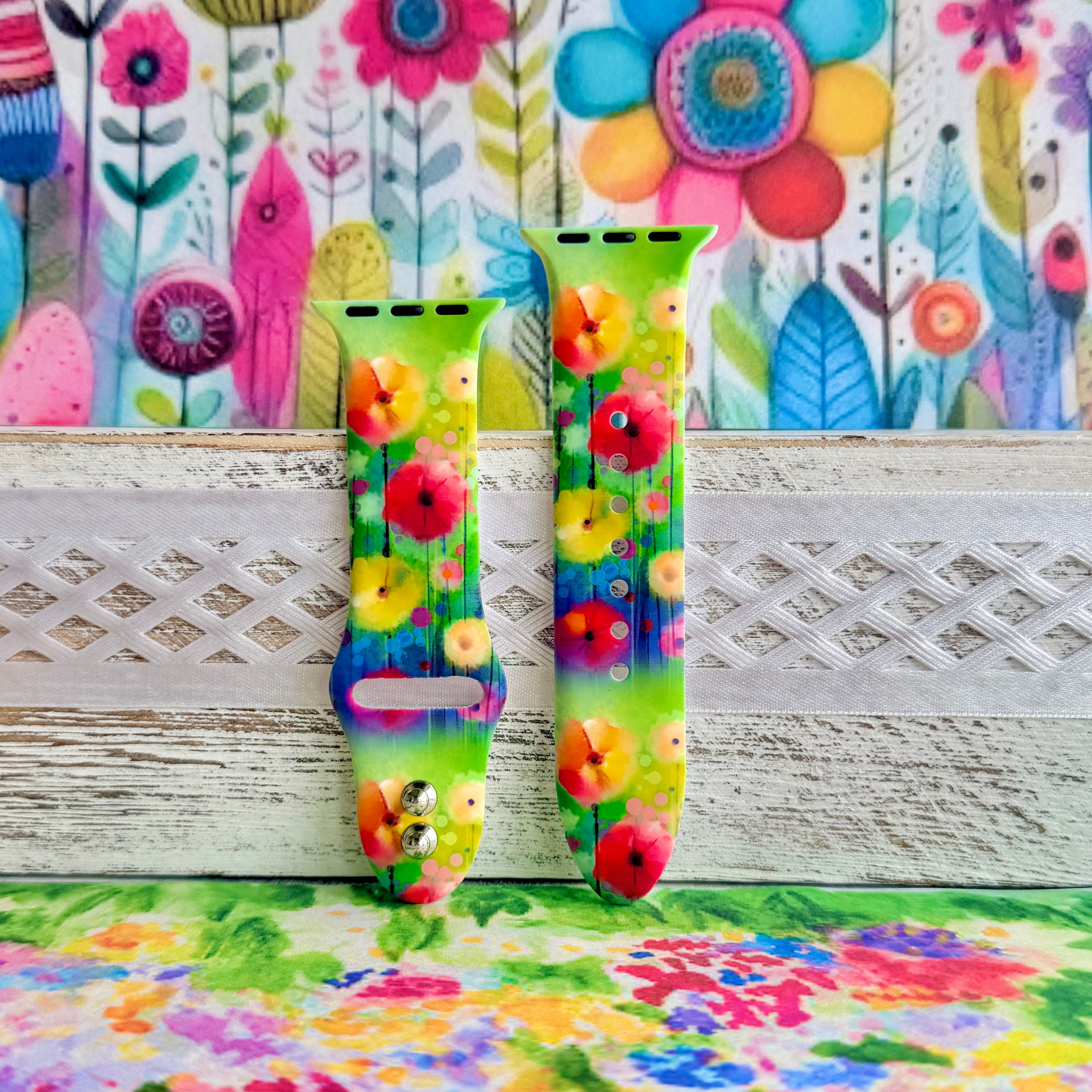 Petal Princess Apple Watch band with vibrant watercolor flowers in red, orange, yellow, pink, and blue on green background

