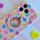Conversation Hearts pattern MagSafe phone grip ring with pastel candy hearts and "Be Mine" text on pink background compatible with iPhone and Samsung