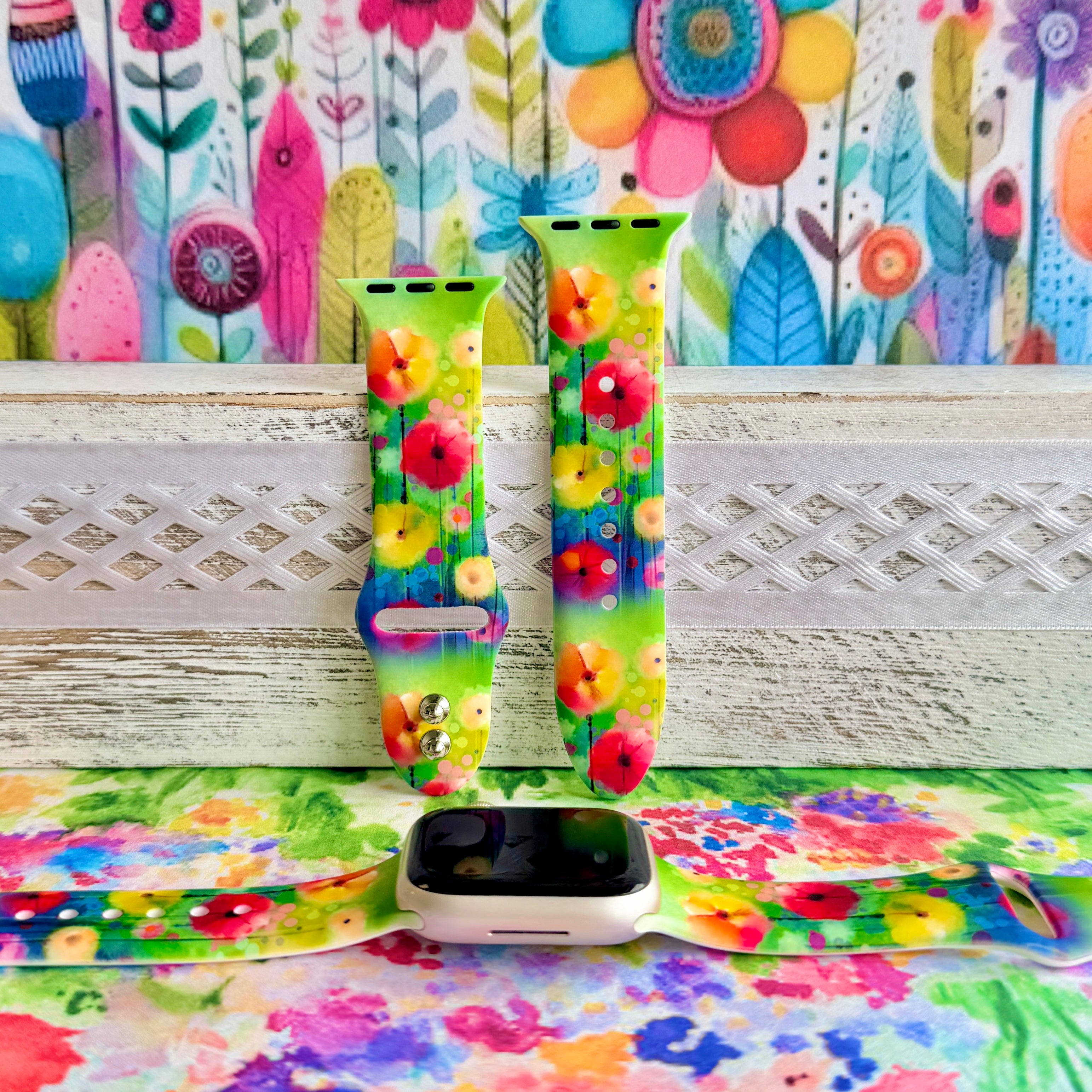 Petal Princess Apple Watch band with vibrant watercolor flowers in red, orange, yellow, pink, and blue on green background
