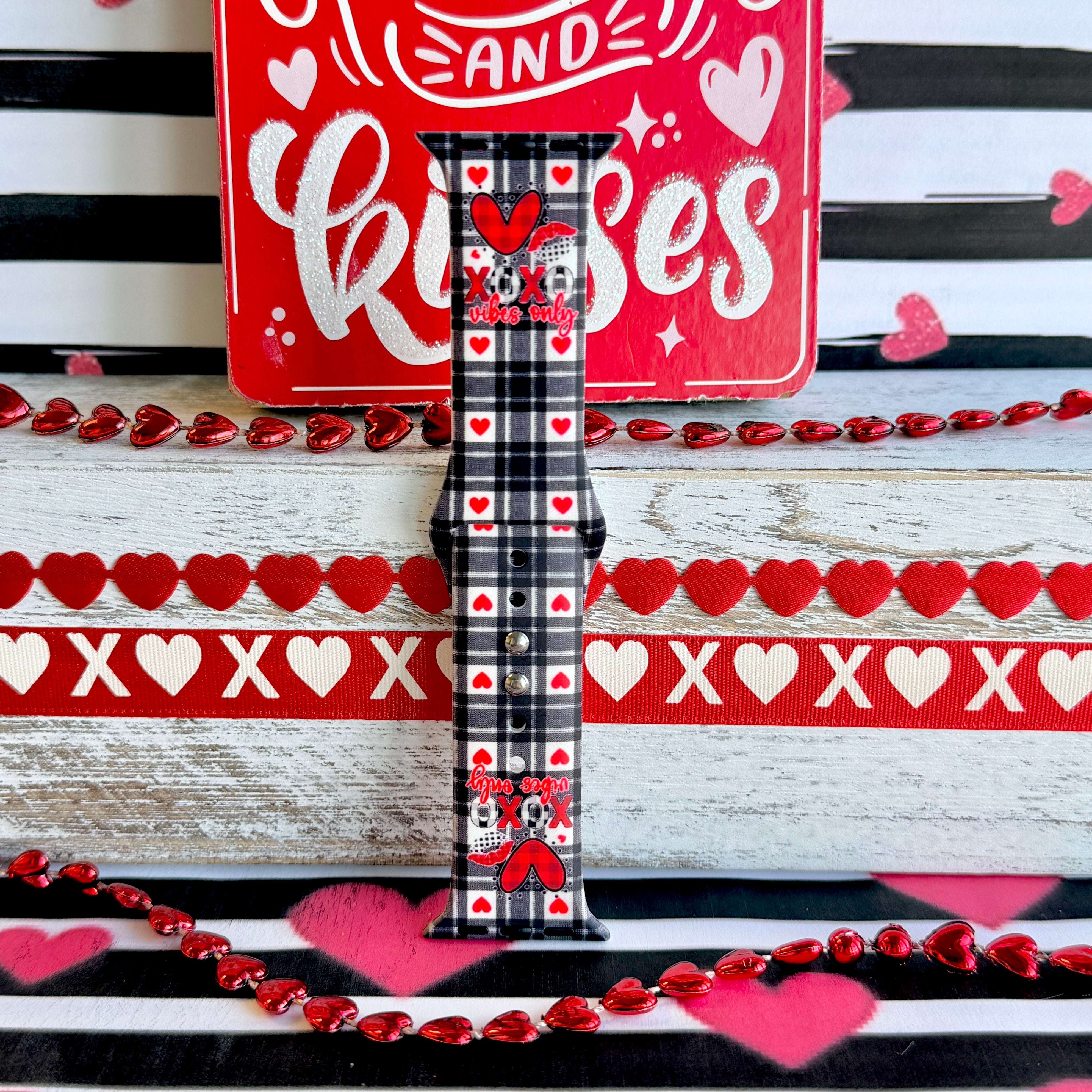 Plaid Crush Vibes Apple Watch band with black buffalo check, red hearts, and XOXO Vibes Only message with Valentine's decorations
