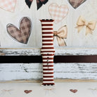 Sweet Espresso Stripes Apple Watch band single strap half standing against a plaid heart and bow backdrop, showing the espresso and cream stripe print.
