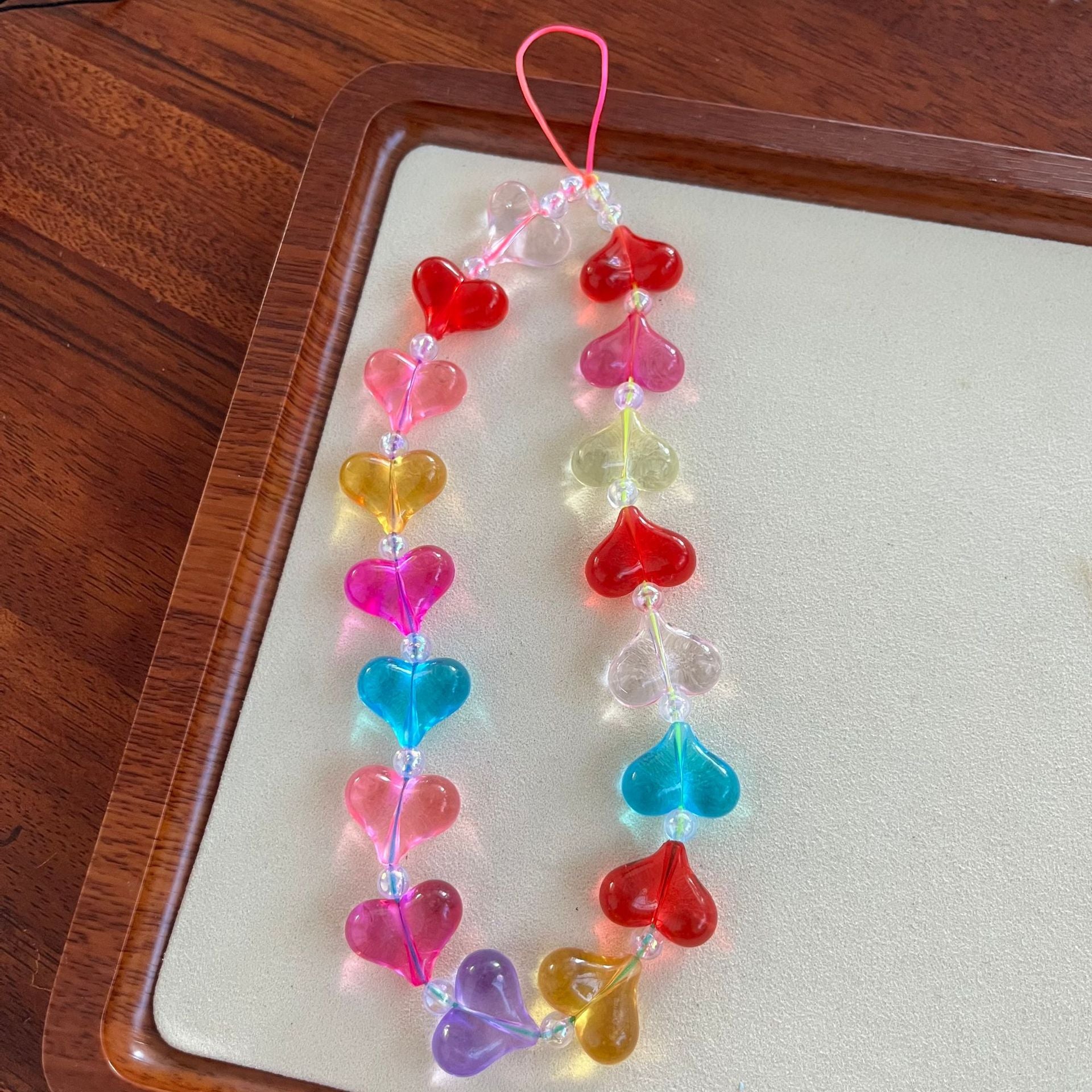 Candy hearts phone charm with translucent rainbow heart beads and crystal accents on conversation hearts phone case
