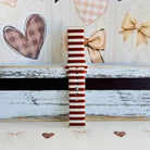 Sweet Espresso Stripes Samsung Galaxy Watch band single strap half standing on weathered wood, showing the espresso and cream stripe print end to end.