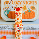 Close-up of the All The Fall Things Apple Watch band showing the watercolor detail on individual pumpkins, coffee cups and cinnamon rolls across the cream strap.