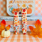 All The Fall Things Apple Watch band with both strap halves standing on weathered wood beside a white pumpkin and orange gingham ribbon, showing the full watercolor collage print.