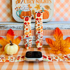 All The Fall Things silicone Apple Watch band shown with an Apple Watch, both strap halves standing upright to display the cream base packed with watercolor pumpkins, pies, coffee cups and autumn leaves.