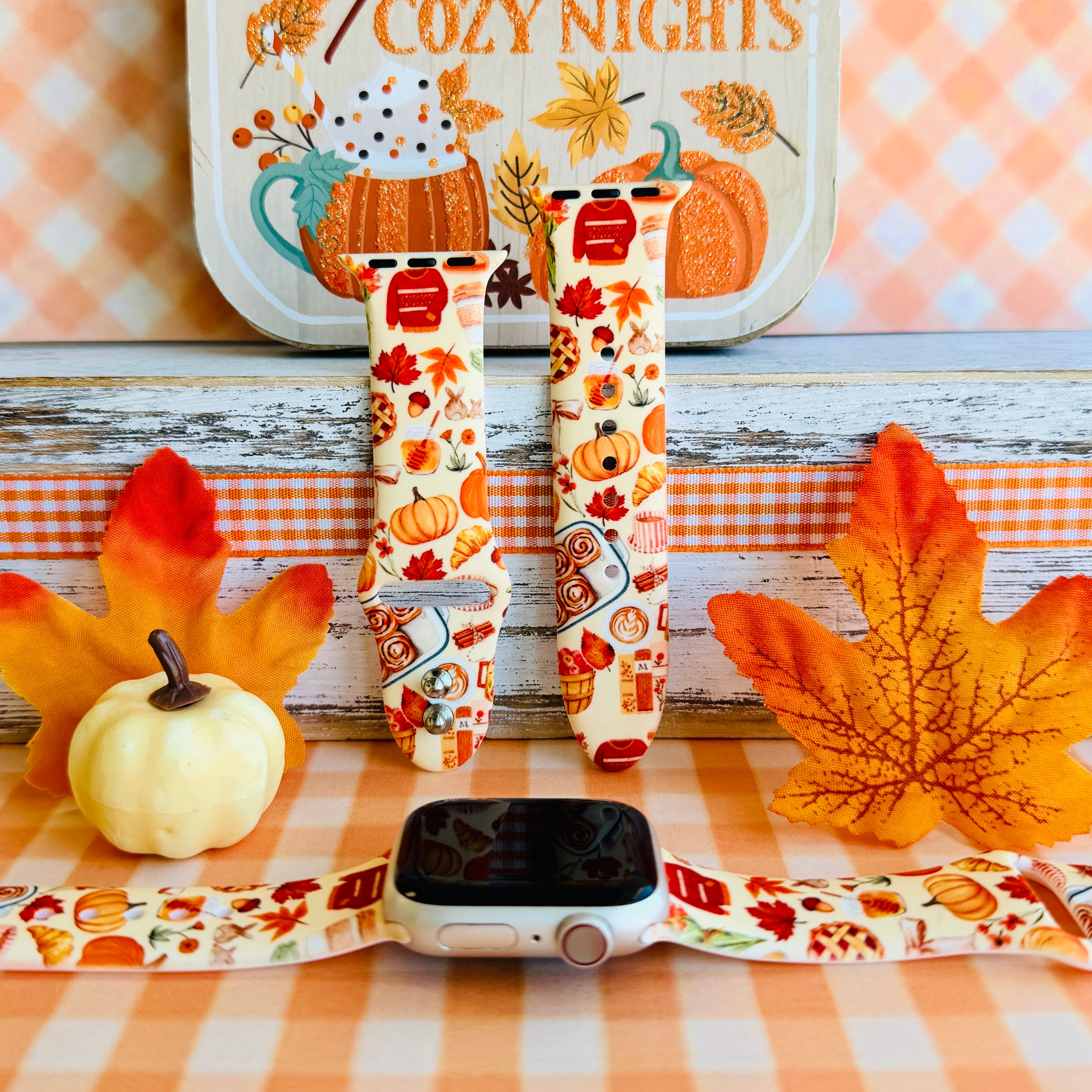 All The Fall Things silicone Apple Watch band shown with an Apple Watch, both strap halves standing upright to display the cream base packed with watercolor pumpkins, pies, coffee cups and autumn leaves.