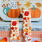 All The Fall Things Samsung Galaxy Watch band front view of both strap halves against a Spice and Cozy Nights fall sign, showing the cinnamon rolls, pumpkins and maple leaves in the print.