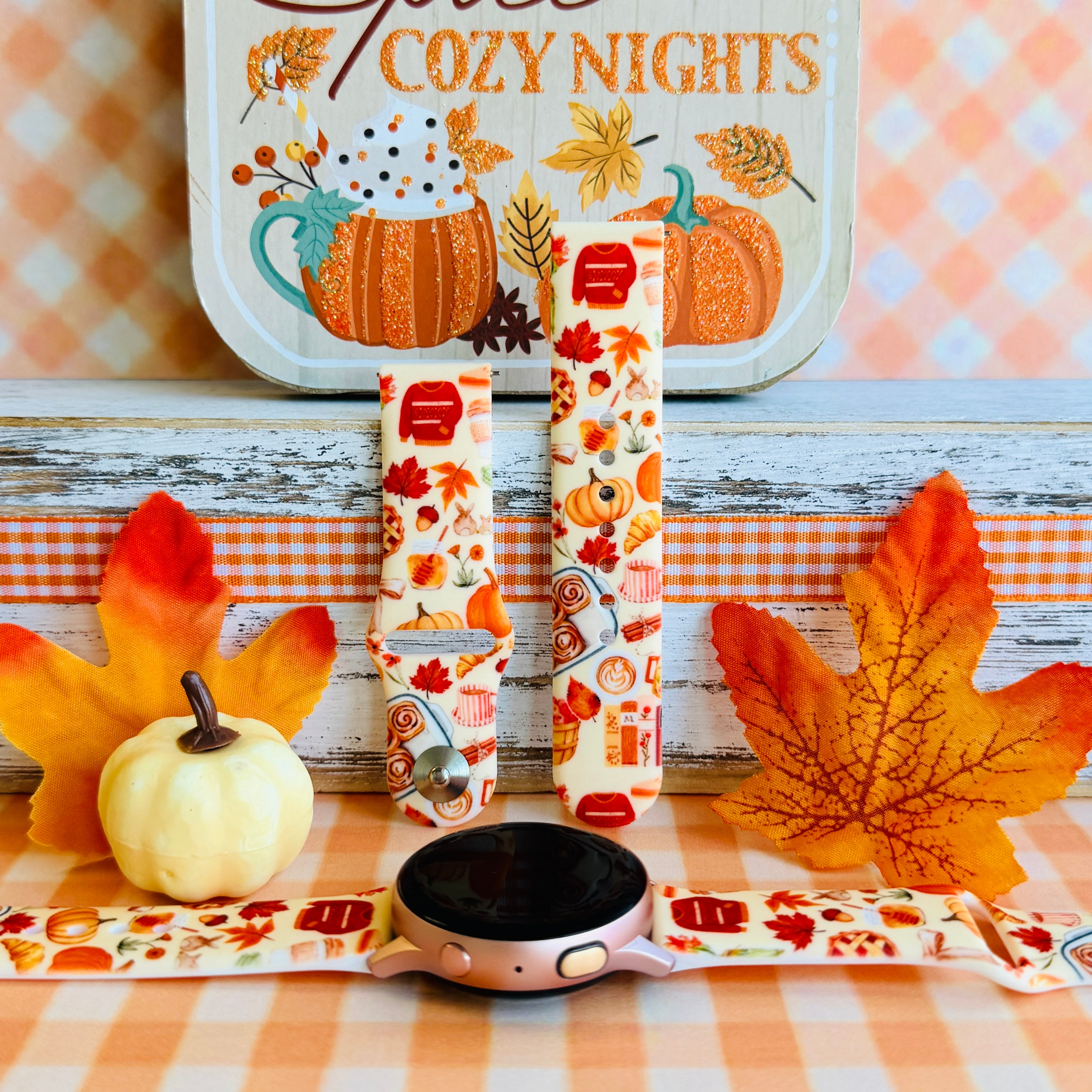 All The Fall Things silicone Samsung Galaxy Watch band shown with a rose gold Galaxy Watch, both strap halves standing upright to display the cream base packed with watercolor pumpkins, pies and autumn leaves.