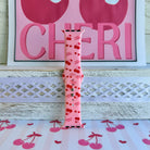 Mon Cheri Apple Watch band with red cherries, hearts, and French text on pink background with CHERI sign
