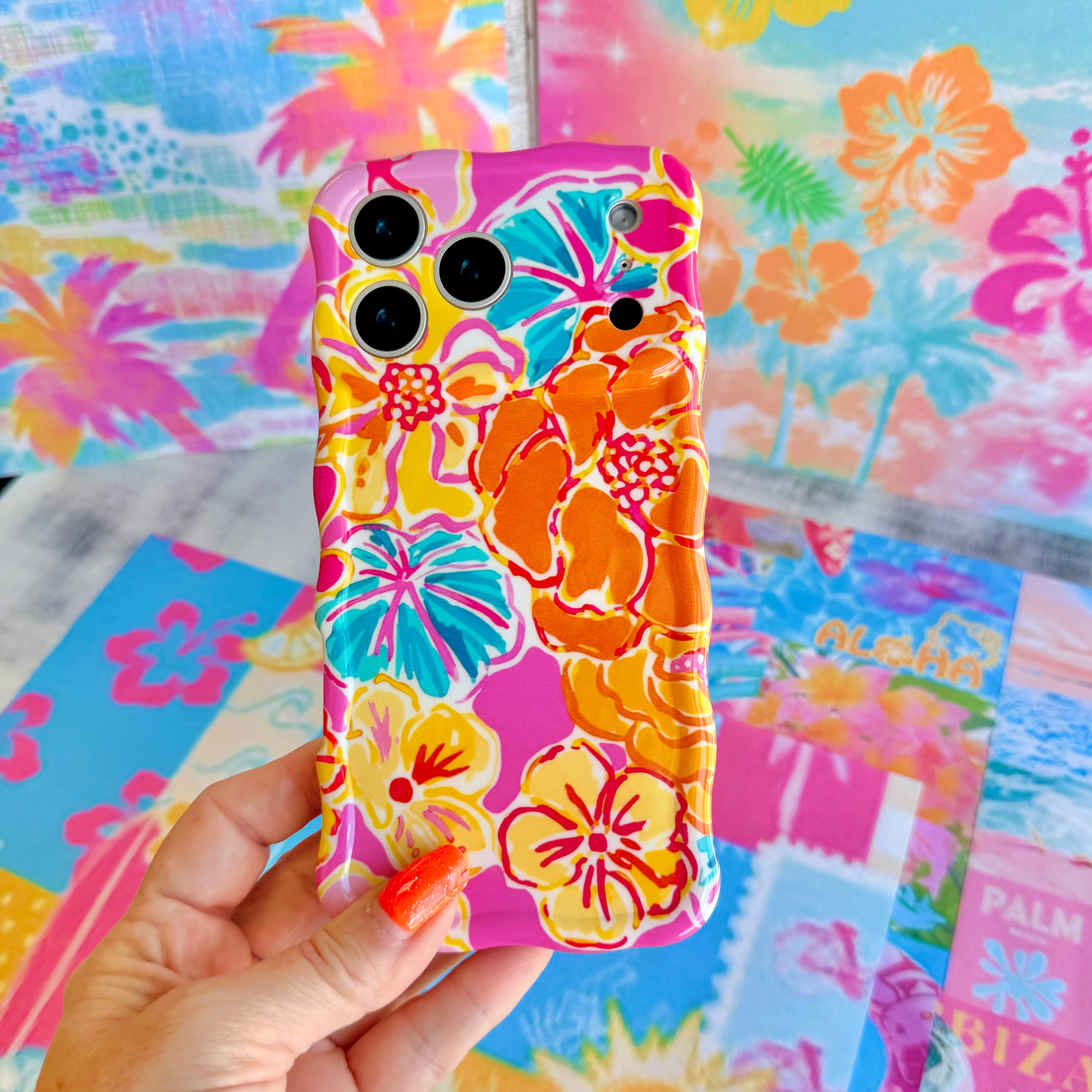 Trendy wavy iPhone case featuring a vibrant pink, orange, and teal hibiscus flower pattern with a high-gloss finish.