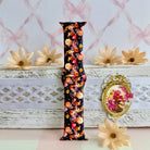 Twilight Bouquet Apple Watch band with vibrant pink, coral, and yellow flowers on black background with white daisies
