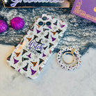 Witch Please MagSafe grip ring lying beside the matching cream witch hat Wavy Luxe case with purple glitter pumpkins.