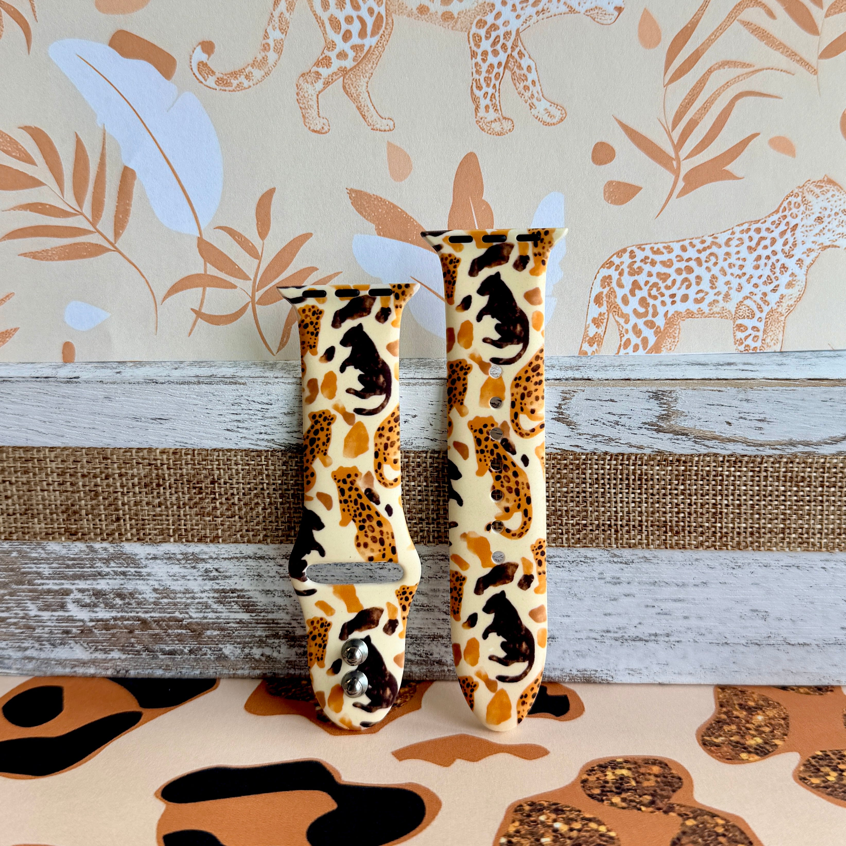 Golden Wildcat Apple Watch band with spotted leopards in golden and brown tones on cream background with safari wallpaper
