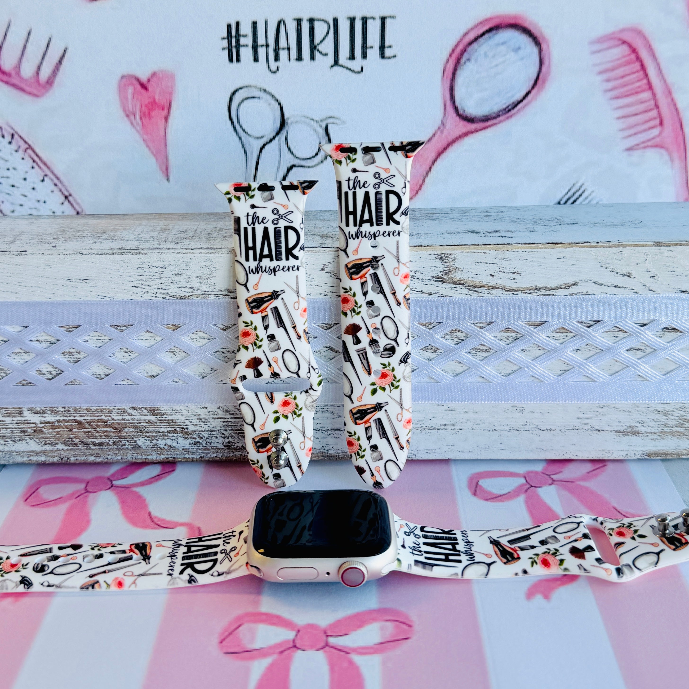 Hair Whisperer Apple Watch band with hairstyling tools, scissors, combs, and roses on white background with #HAIRLIFE backdrop
