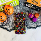 Spooky Wavy Luxe MagSafe iPhone case with the matching MagSafe grip ring attached, styled with orange pails and purple felt pumpkins.